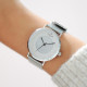 White dial and contemporary designed watch with its Milanese mesh bracelet in silver